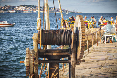 People on pier by sea against sky