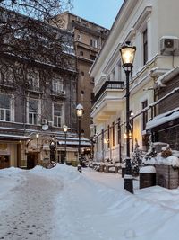 Snow covered street and buildings in city