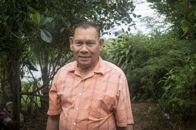 Senior man standing by in forest