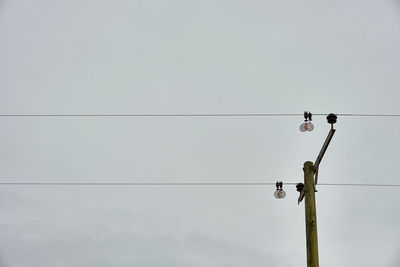 Low angle view of electricity pylon against sky