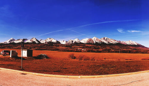 Scenic view of snowcapped mountains against blue sky