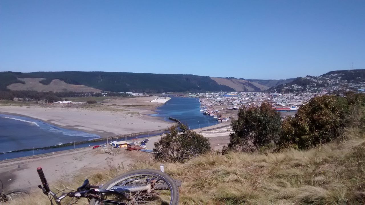 clear sky, beach, sea, copy space, water, blue, mountain, sand, scenics, shore, tranquil scene, tranquility, high angle view, beauty in nature, nature, sunlight, tree, coastline, transportation, landscape