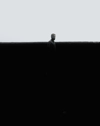 Rear view of silhouette man standing against clear sky