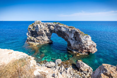 Rock formations in sea against sky