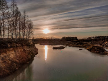 Scenic view of river against sky at sunset