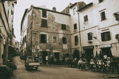 People on street amidst buildings in city