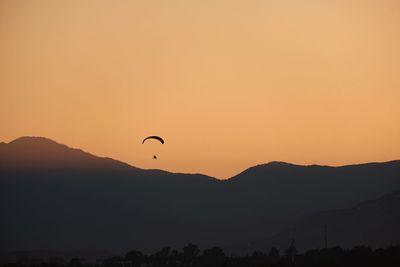 Scenic view of silhouette mountains against orange sky