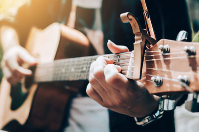 Midsection of man playing guitar