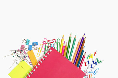 High angle view of multi colored pencils against white background