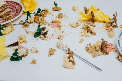 Toy soldiers fight in between pieces of cakes about having a dessert or not - close up food on table