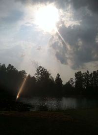 Scenic view of river against cloudy sky