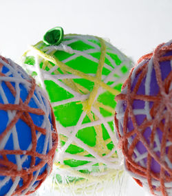 Close-up of multi colored candies on table against white background