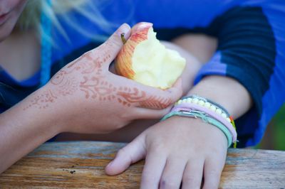 Midsection of woman holding food while sitting on table