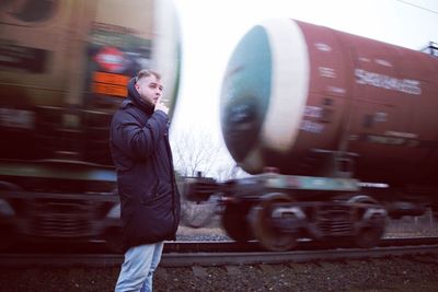 Side view of man standing by train