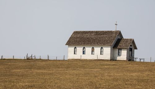 House on field against clear sky