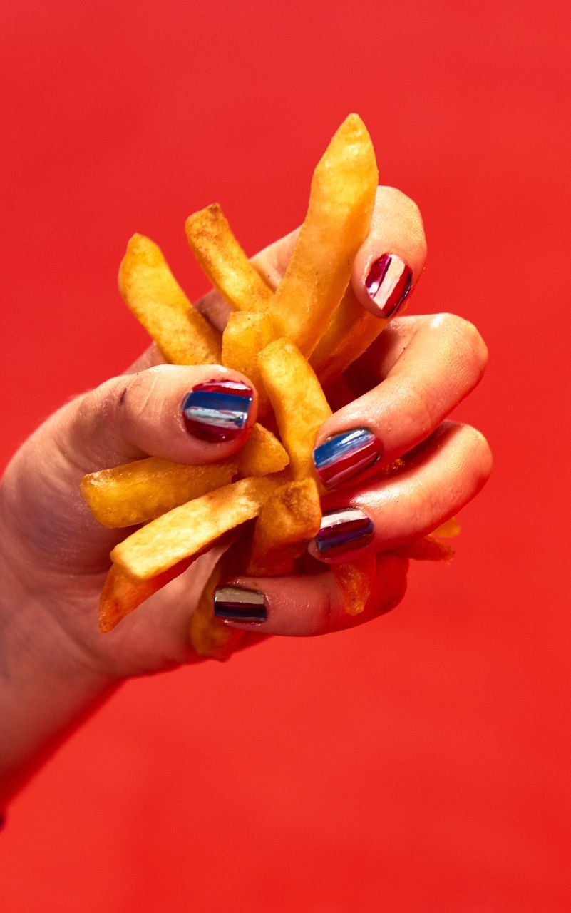 human hand, food and drink, human body part, holding, food, human finger, real people, one person, close-up, studio shot, unhealthy eating, lifestyles, red, indoors, ready-to-eat, freshness, people