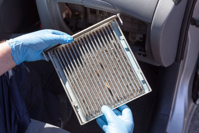 Cropped hands holding equipment in car