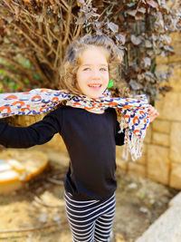 Portrait of young woman standing against wall
