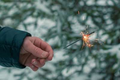 Burning sparklers in a hand outdoors