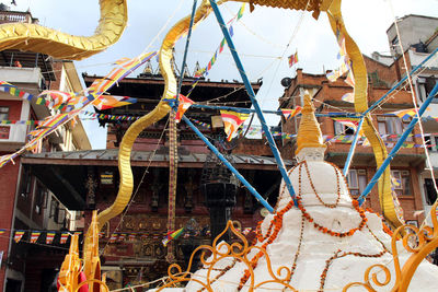 Close-up of ferris wheel against buildings