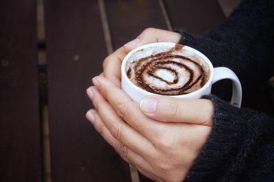 Midsection of woman holding coffee cup