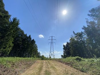 Low angle view of electricity pylon on field against sky