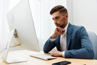 Side view of businessman working at desk in office