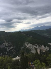 Rear view of people standing on mountain against sky