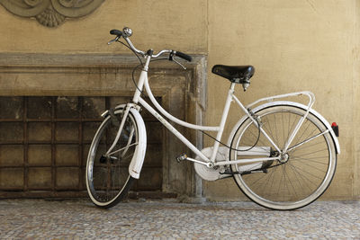 Bicycle parked against wall in city