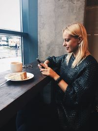 Young woman having cake and coffee