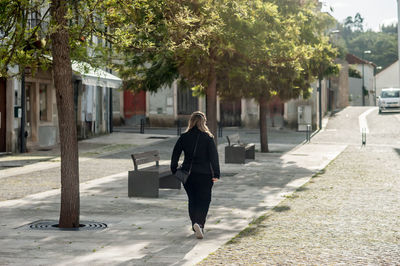 Rear view of woman walking on street in city