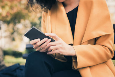 Midsection of woman using mobile phone