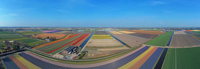 High angle view of road amidst field against blue sky