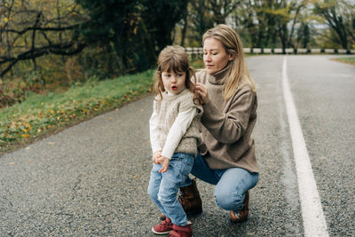 Portrait of smiling young woman standing on road