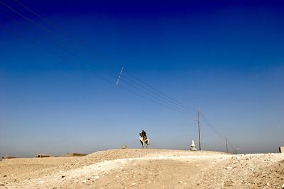 Full length of woman photographing against clear sky