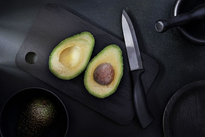 Avocado on a cutting table ready to cut. black background