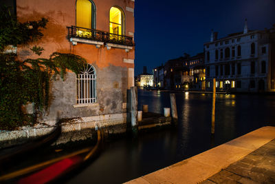 Canal passing through city buildings at night