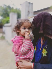 Close-up of mother and daughter standing outdoors