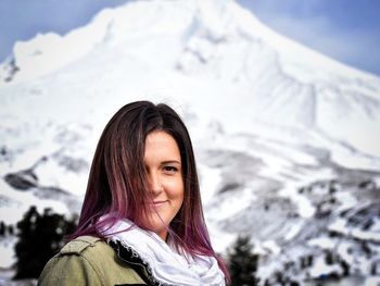 Portrait of young woman against snowcapped mountain