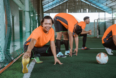 Low section of man playing soccer at park