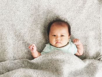 Portrait of cute baby lying on bed