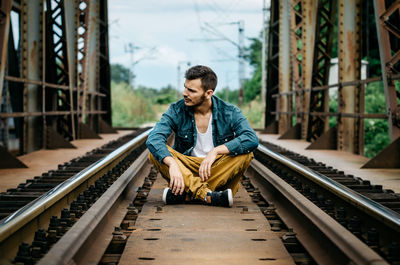 Man sitting on railroad track