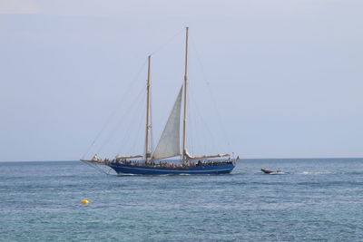 Sailboat sailing on sea against clear sky