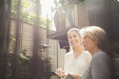 Thoughtful businesswomen standing at office yard on sunny day