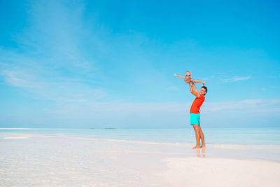 Full length of man standing on beach against sky