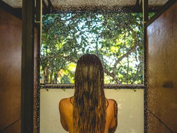 Rear view of woman showering