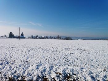 Scenic view of snow covered field against sky