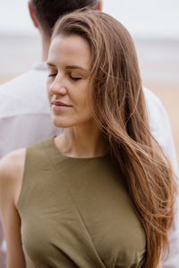 Portrait of a couple in love, a man and a woman hugging walking along the beach on the sand