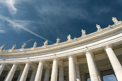 Low angle view of neo-classical portico against blue sky