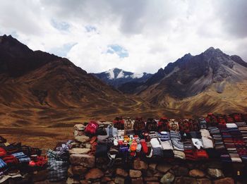 Sweaters on rock for sale against mountains